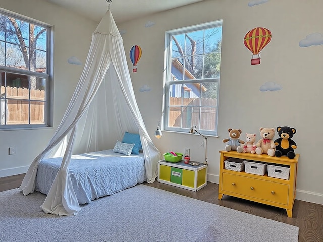 bedroom featuring baseboards, multiple windows, and dark wood-type flooring
