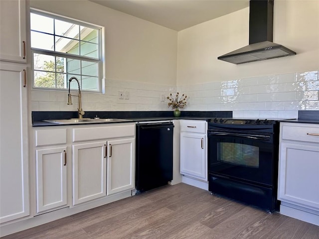 kitchen with light wood finished floors, decorative backsplash, black appliances, and wall chimney exhaust hood