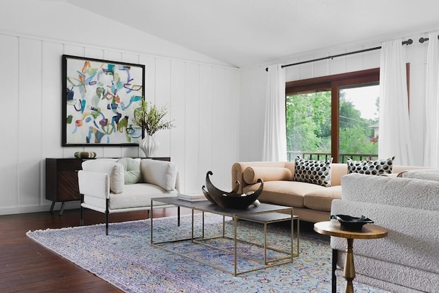 living room with a decorative wall, hardwood / wood-style floors, and vaulted ceiling