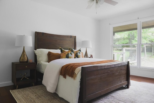 bedroom featuring multiple windows, ceiling fan, baseboards, and wood finished floors