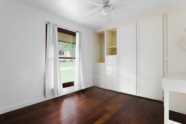 unfurnished bedroom with ceiling fan, baseboards, and dark wood-style flooring