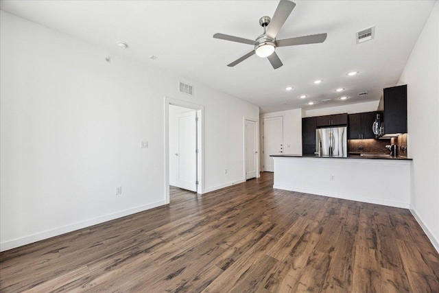 unfurnished living room with visible vents, baseboards, a ceiling fan, and dark wood-style flooring