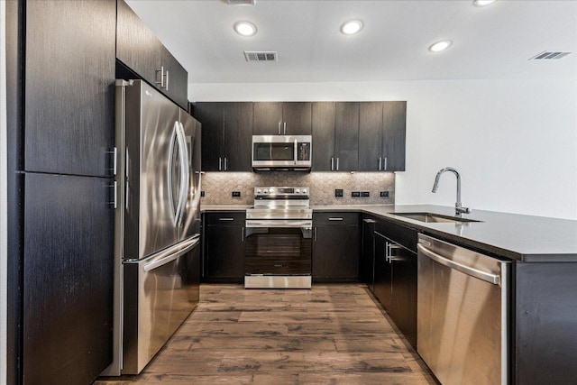 kitchen with a sink, visible vents, appliances with stainless steel finishes, and a peninsula