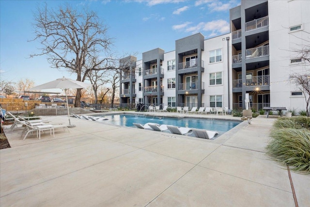 pool with a patio area and fence