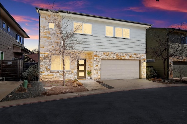 view of front of house with stone siding, concrete driveway, and a garage