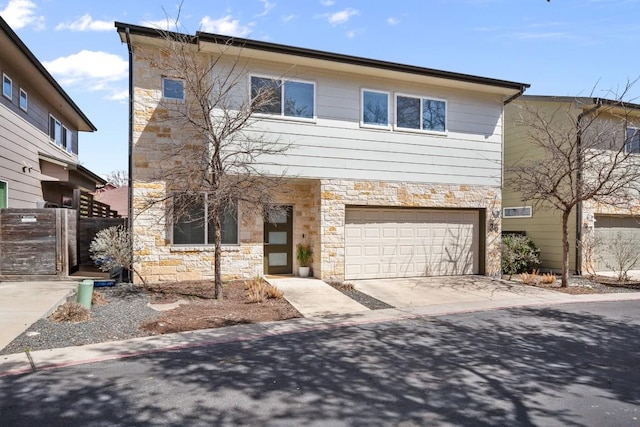 view of front of property featuring concrete driveway, an attached garage, and stone siding