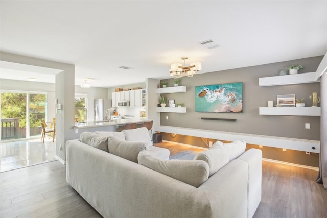 1505 Curameng Cv, Austin, TX 78748 - living room featuring wood finished floors and a chandelier
