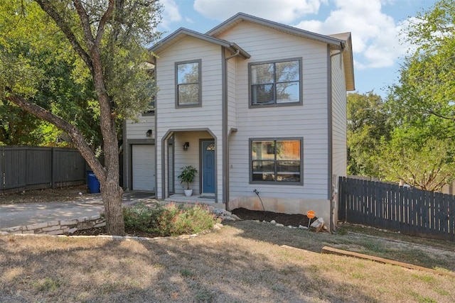 view of front of property featuring a garage, driveway, and fence