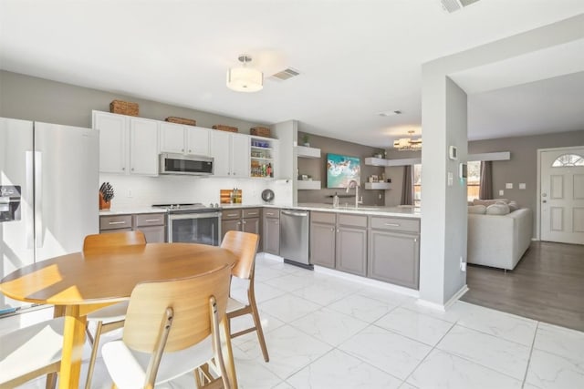 kitchen featuring visible vents, marble finish floor, appliances with stainless steel finishes, and open shelves