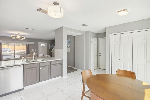 1505 Curameng Cv, Austin, TX 78748 - kitchen with stainless steel dishwasher, gray cabinets, a chandelier, and light stone countertops