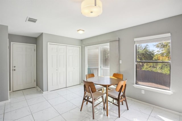 dining room featuring baseboards, visible vents, and marble finish floor