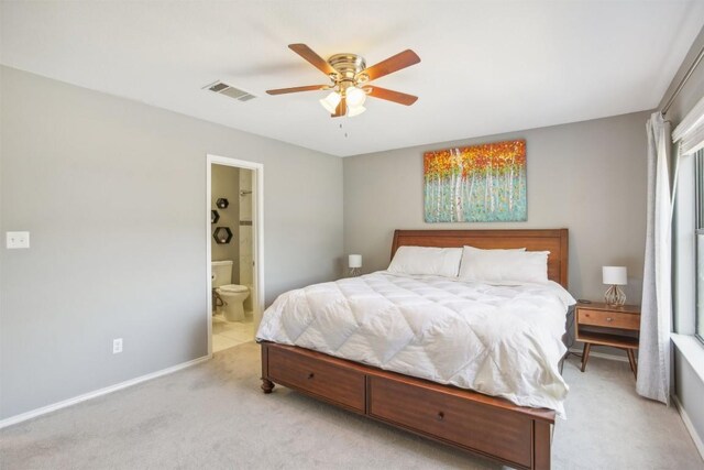 bedroom with visible vents, baseboards, light carpet, ensuite bath, and a ceiling fan