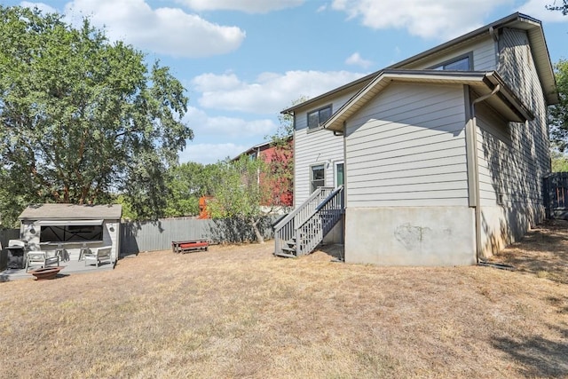 view of side of home featuring a yard and fence