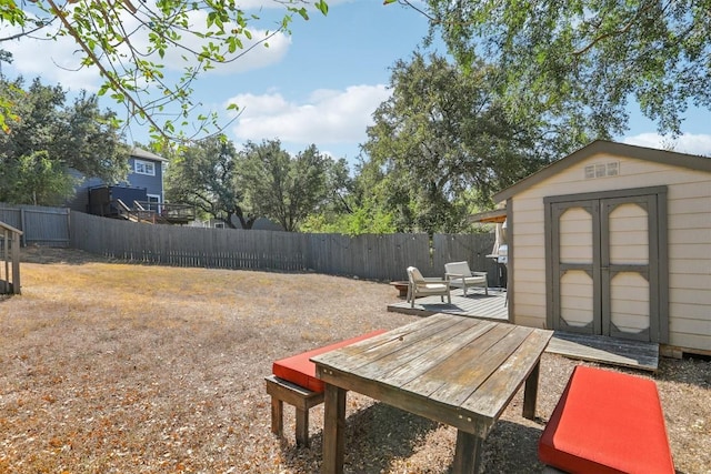 view of yard featuring a storage unit, an outbuilding, and a fenced backyard