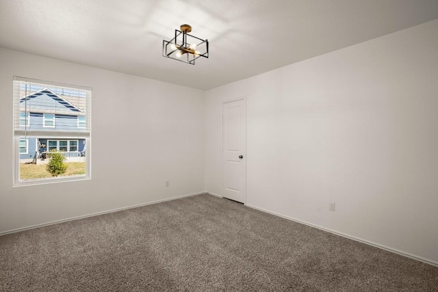 carpeted empty room with baseboards