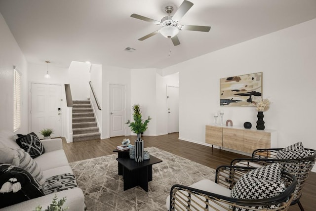 living area featuring visible vents, wood finished floors, stairway, baseboards, and ceiling fan