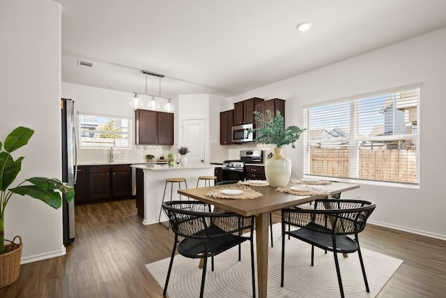 dining space with recessed lighting, wood finished floors, visible vents, and baseboards