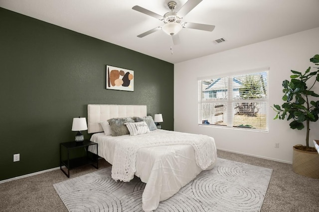 carpeted bedroom with visible vents, baseboards, and ceiling fan