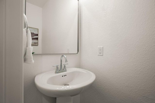 bathroom with a textured wall and a sink