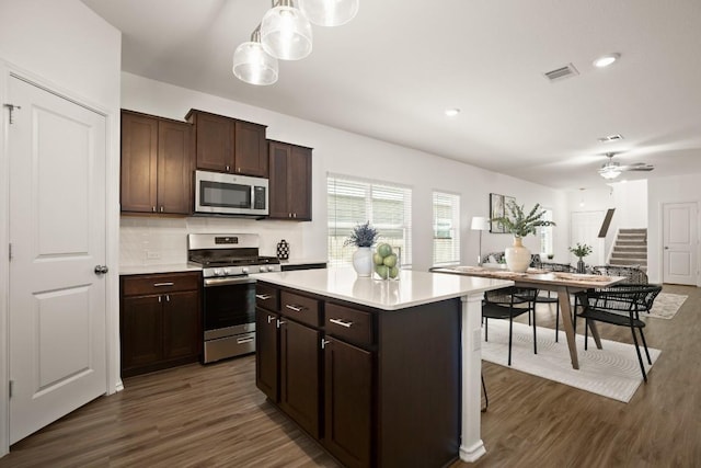 kitchen with light countertops, dark wood finished floors, tasteful backsplash, and stainless steel appliances