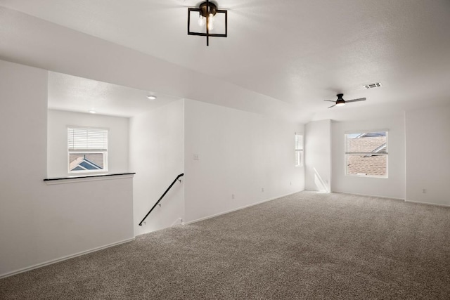 spare room with baseboards, visible vents, carpet flooring, and a wealth of natural light