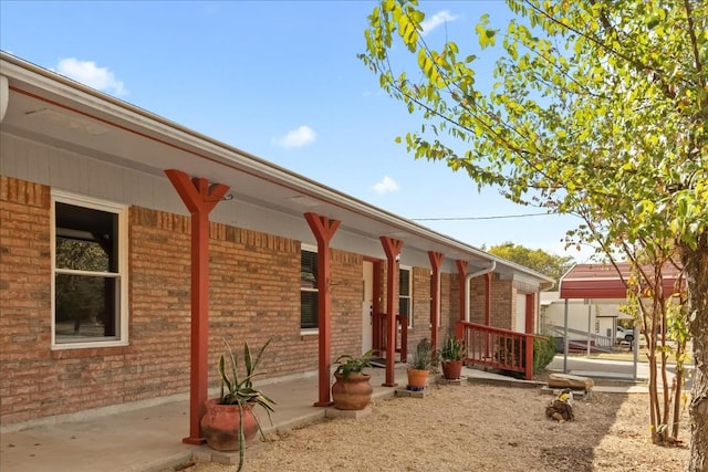 exterior space with brick siding and covered porch