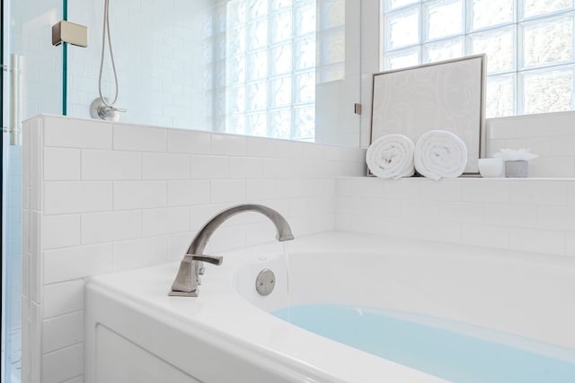 full bathroom with a garden tub and plenty of natural light