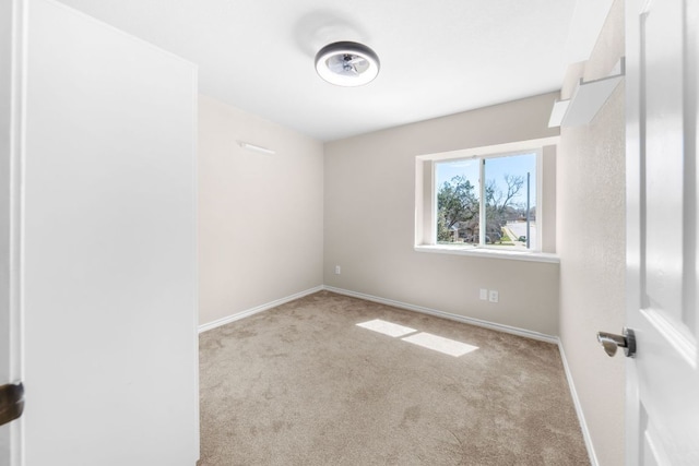 spare room featuring carpet and baseboards