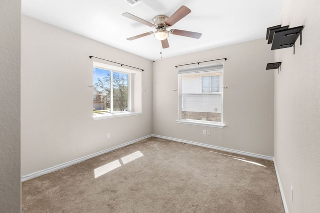 unfurnished room featuring baseboards, carpet floors, and a ceiling fan