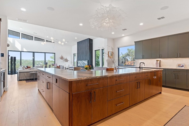 kitchen with a large island, open floor plan, modern cabinets, and visible vents