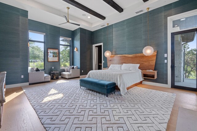 bedroom with visible vents, wallpapered walls, beam ceiling, multiple windows, and a towering ceiling