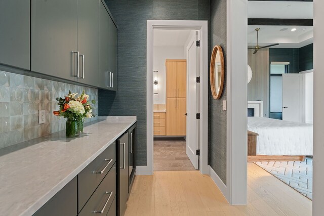 interior space with light stone counters, backsplash, and light wood-type flooring