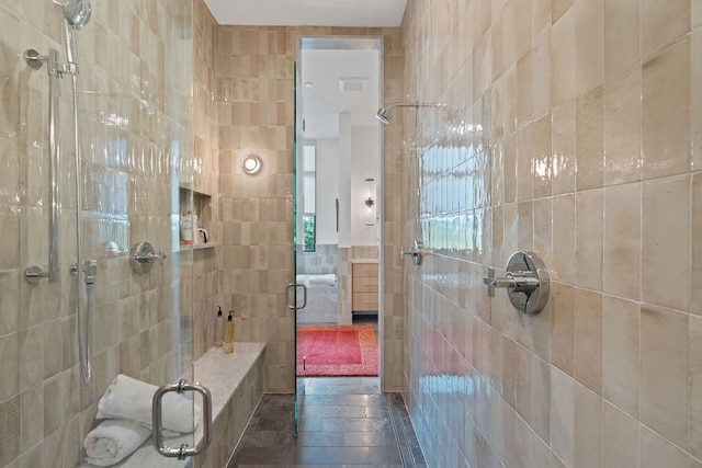 full bath featuring tile walls and a shower stall