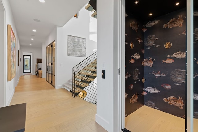 hallway with recessed lighting, stairs, light wood-type flooring, and baseboards