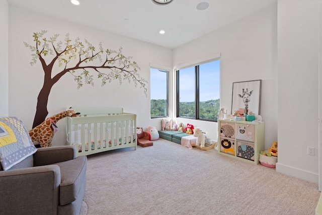 bedroom featuring recessed lighting, baseboards, a nursery area, and carpet floors