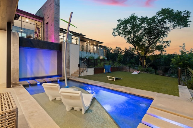 view of swimming pool featuring a fenced in pool, fence, and a lawn