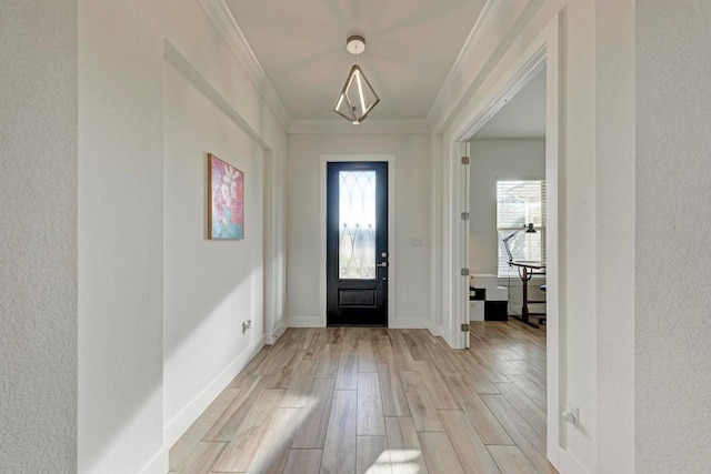 foyer with baseboards, light wood-type flooring, and crown molding