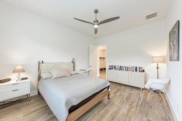 bedroom featuring visible vents, a ceiling fan, light wood-style flooring, and baseboards