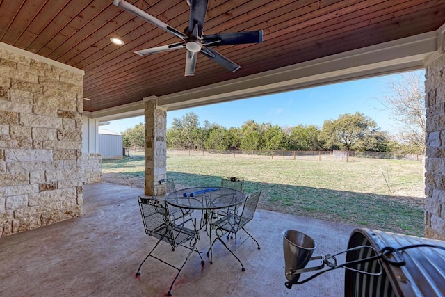view of patio with outdoor dining space, a ceiling fan, and a fenced backyard