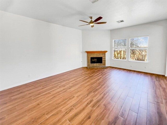 3128 Flinders Reef Ln, Austin, TX 78728 - unfurnished living room with ceiling fan, wood finished floors, and a brick fireplace