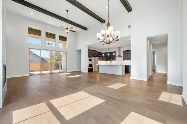 802 Serene Estates Dr, Austin, TX 78738 - unfurnished living room featuring dark wood-style floors, a high ceiling, ceiling fan with notable chandelier, and baseboards