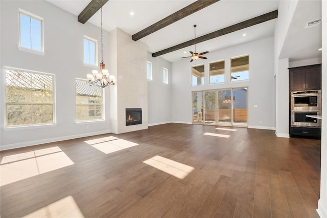 802 Serene Estates Dr, Austin, TX 78738 - unfurnished living room with baseboards, ceiling fan with notable chandelier, a towering ceiling, and dark wood-type flooring