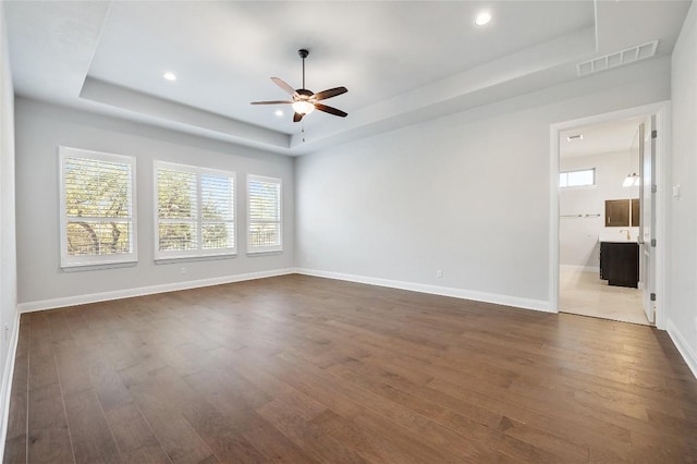 802 Serene Estates Dr, Austin, TX 78738 - unfurnished room with dark wood-style flooring, ceiling fan, a tray ceiling, and visible vents