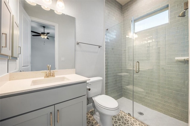 full bath with a stall shower, toilet, vanity, and ceiling fan