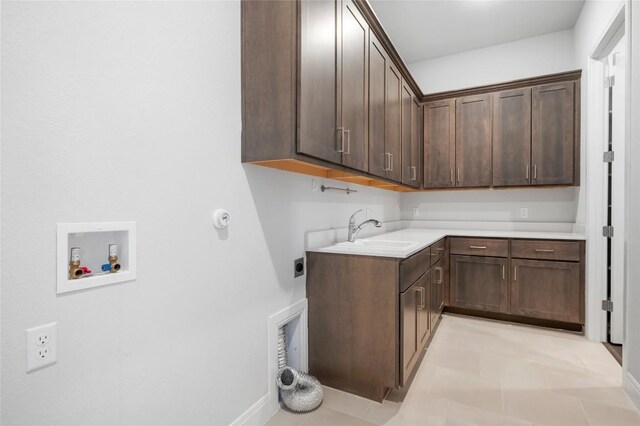 washroom with hookup for a washing machine, baseboards, hookup for an electric dryer, cabinet space, and a sink