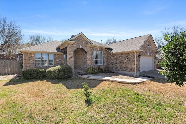 single story home featuring a front lawn, fence, roof with shingles, an attached garage, and brick siding