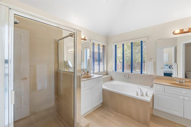 bathroom featuring a shower stall, two vanities, and a sink