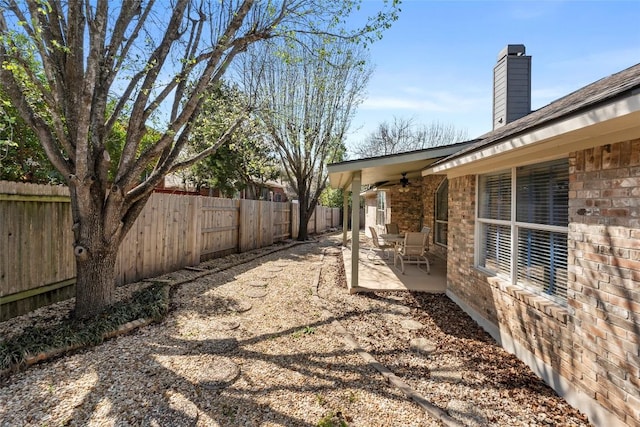 view of yard with a patio area, a fenced backyard, and ceiling fan