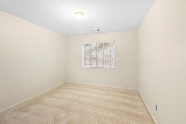 carpeted spare room with visible vents and baseboards