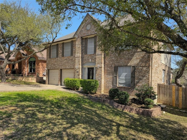 traditional home featuring brick siding, fence, concrete driveway, a front yard, and an attached garage